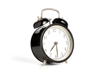 Closeup retro black alarm clock isolated on white background with clipping path, perspective view