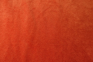 Top view of reddish orange artificial suede fabric