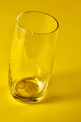 Transparent empty glass in yellow background