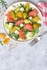 Avocado salad with grapefruits, tomato, feta cheese, arugula and sunflower seeds. Top view with copy space.