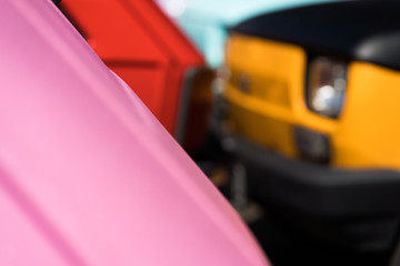 Two small cars of different colors on the road