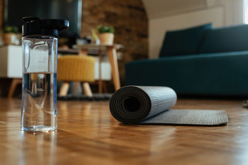 Exercise mat and water bottle on the floor.