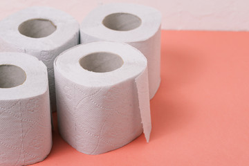 Toilet paper on a pink background with copy space. Sanitary and household supplies.