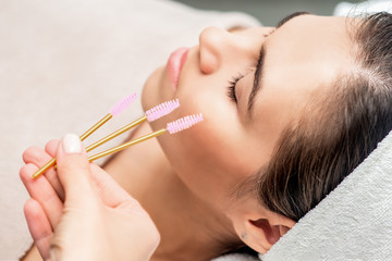 Eyelash brushes in hand.