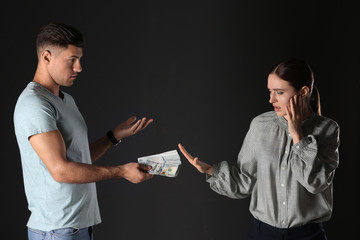 Woman refusing to take bribe on black background