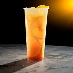 Ice fresh orange juice fruit drink on black background