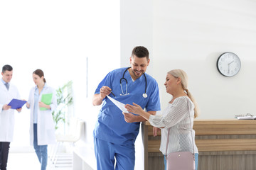 Doctor talking with patient in hospital hall