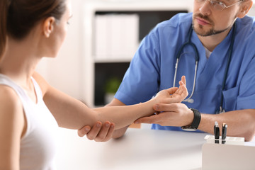 Obraz premium Male orthopedist examining patient's arm in clinic, closeup