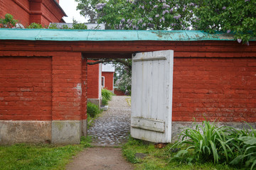 Red brick wall with a white wooden door.