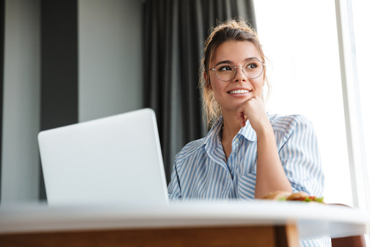 Image of happy nice woman working with laptop and smiling