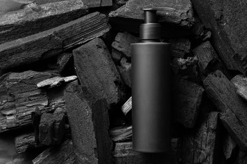 Mock up cosmetic jar with cream, shampoo, serum. The background is black coal. Black design.