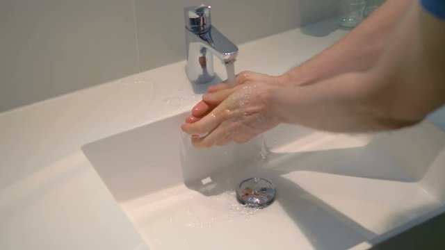 Man washing hands under flowing water from faulty tap in 4K slow motion 60fps - Powered by Adobe