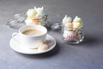 Small Meringues in Glass Jars and Cup of Coffee on Gray Background Tasty Dessert for Coffee or Tea Gift for Holidays Horizontal Copy Space