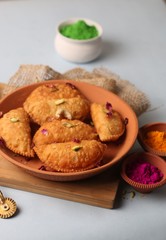 Popular Holi Snack known as Karanji or Gujia is Served on earthen platter. (Holi Concept)