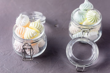 Small Meringues in Glass Jars on Gray Background Tasty Dessert Gift for Holidays Horizontal Copy Space