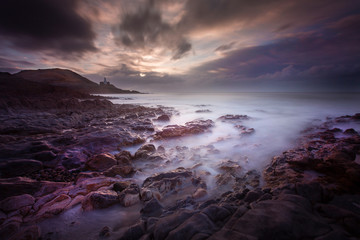 Daybreak over Bracelet Bay with a long exposure over the rock pools on the Gower peninsula in Swansea, South Wales, UK