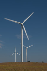 Fototapeta premium Wind Turbines Against Blue Sky in Rural Area