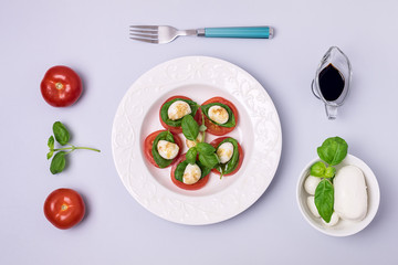 White Plate of Classic Italian Caprese Salad Ripe Tomatoes Fresh Basil Leaf Bowl with Mozarella Cheese Flat Lay Top View Salad and Ingredients Copy Space