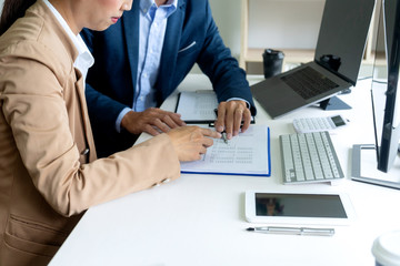 business man and woman sit at the table looking at computer