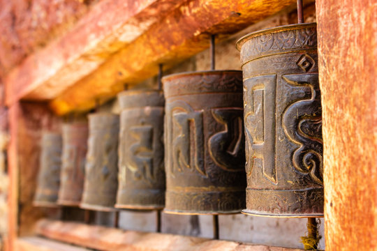 Prayer wheels with tibetan mantras on a red walls inside the ancient Buddhist monastery in the Himalayan village of Nako in Kinnaur, India.