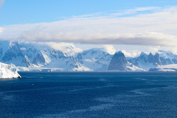 Fototapeta na wymiar Snow-capped mountains and icy shores of the Bismarck Strait in the Antarctic Peninsula, Antarctica
