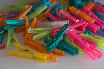 heap of plastic and colored clothespins - closeup view - green, pink, yellow, orange, purple, white