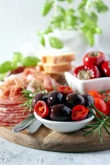 Antipasto - olives, ham, salami, tomato, pepper and bread. Top view with copy space.