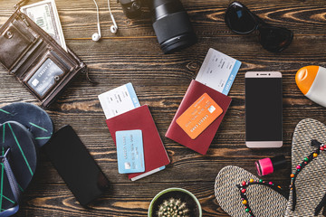 Preparing for a trip for a couple. Airline tickets, money, credit cards, passports, phones, headphones, glasses