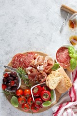 Antipasto: ham, olives, salami, tomato, pepper and bread. Top view with copy space.