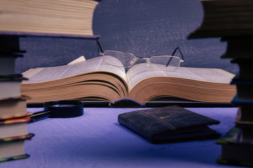 Big book on the table through a stack of books with a place for text, writer day, poet, library.