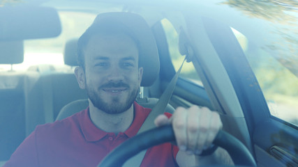 Portrait young smiling man driving a car on a road trip sunset sunlight transport holiday happy adventure car short hair free time journey smiling summer travel slow motion