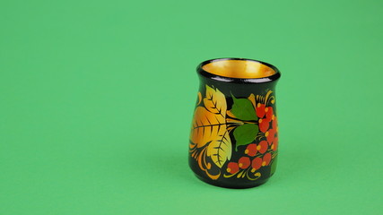 multi-colored gold on black with red and green tableware made of wood hand-painted on a green background