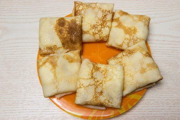 pancakes in a plate on a wooden background