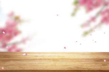 Beautiful Unfocus pink Sakura flowers branch as frame with select focus at wooden table top