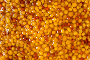 French mustard in a glass jar, shot on a yellow background. Background for seasoning and nutrition.