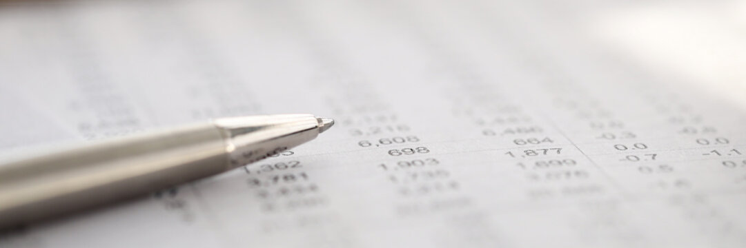 Stylish silver pen rests on report with numbers