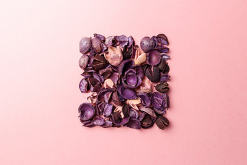 Frame made of purple and pink dry flowers, branches, leaves and petals on pastel pink background. Colorful background image. Top view. Flat lay. Copy space. Art concept. Color trends 2020