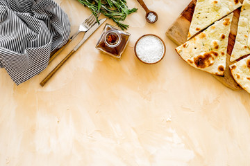 Italian focaccia with cheese and rosemary on beige background top-down copy space