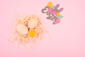 Easter concept on a pink background. Egg on a wooden spoon. A tray of eggs on a white and pink background. eco tray with testicles. minimalistic trend, top view. Egg tray. Easter concept.