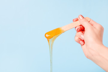 depilation and beauty concept - sugar paste or wax honey for hair removing with wooden waxing...