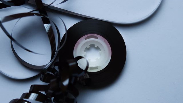 Cassette reel in slow motion over white background. Retro abstract music background concept.