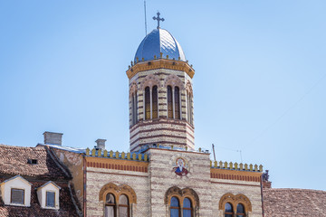 Tower over gate to Church of Assumption of Virgin Mary in central square on the Old Town of Brasov...