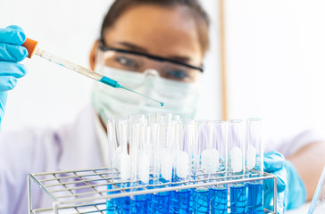 Scientists are carrying blue chemical test tubes to prepare for the determination of chemical composition and biological mass in a scientific laboratory, Scientists and research in the lab Concept.