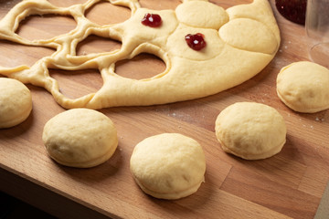 Filling homemade doughnuts made from yeast dough with marmalade