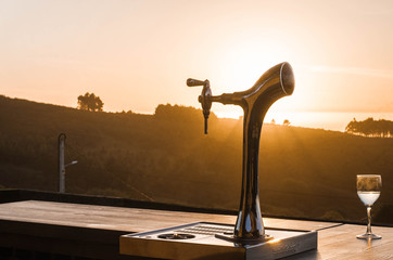 Grifo de cerveza con atardecer de fondo
