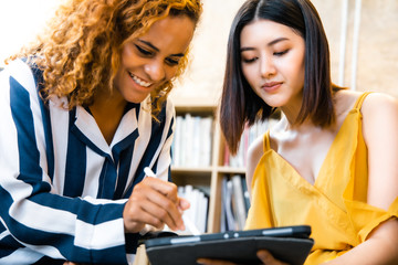 Casually dressed female colleagues talking in a meeting room.Start up Team employees discussing document at meeting.Business People Meeting Design Ideas Concept