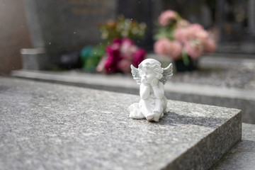 stoned angel at cemetery, graveyard on a bcakground, grave sculpture