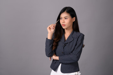 .An Asian businesswoman in a blue suit is thinking hard.