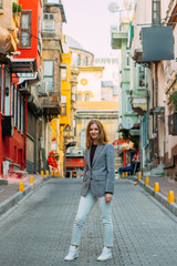 Beautiful smiling girl with blond hair stands on old street of Istanbul
