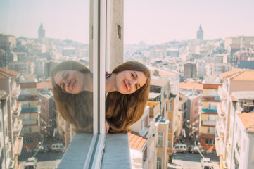 Beautiful smiling girl with blond hair looking from the window in old district of Istanbul - 327873139